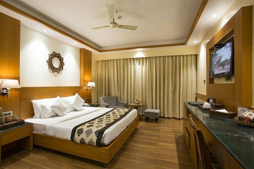 a hotel room with a bed and a flat screen tv at Divine Resort & Spa in Rishīkesh