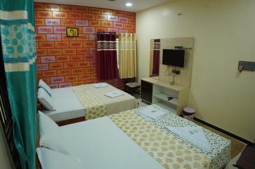 a hotel room with two beds and a mirror at Arjun Homestay in Hampi