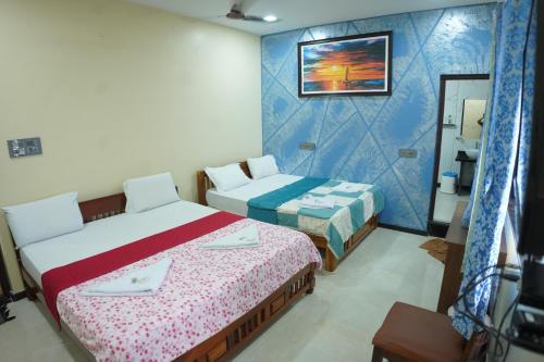 a hotel room with two beds and a mirror at Arjun Homestay in Hampi