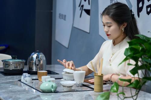 a woman sitting at a table eating food at Qijianyunshe in Hanqiyu