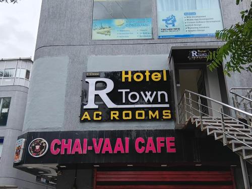 a hotel town ac rooms sign on the side of a building at Hotel R Town in Vadodara