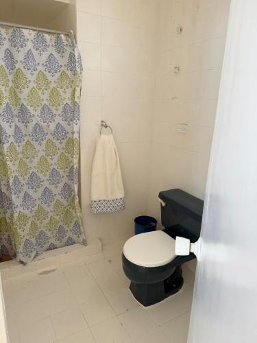 a bathroom with a toilet and a shower curtain at Apartamento vista al mar Seaview apartment in Pampatar