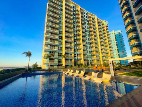 a large building with a swimming pool in front of a building at Luxury 1-Bedroom Apartment Across Okada Manila in Manila