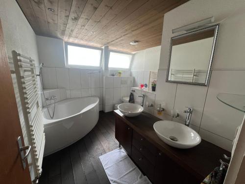 a bathroom with a tub and a sink and a bath tub at Relaxen am Brienzersee mit Terrassen und Grill in Brienz