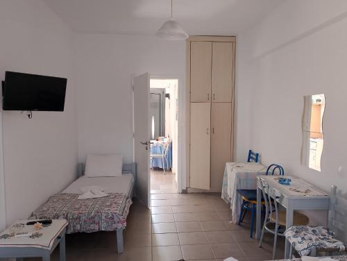 a room with two beds and a table and a tv at Anna Apartments in Agiokampos