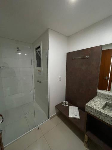 a bathroom with a glass shower and a sink at Hotel Queijo & Cia in Capão Alto