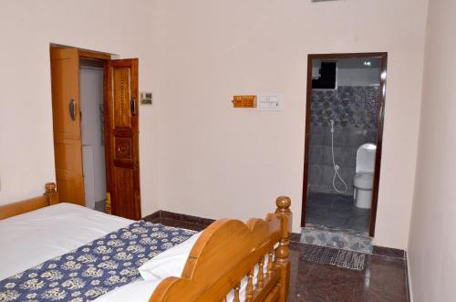 a bedroom with a bed and a bathroom with a shower at AMC Homestay in Tiruvannāmalai