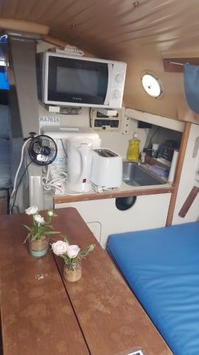 a kitchen with a table with a sink and a tv at Lisboa Barcos Belém in Lisbon