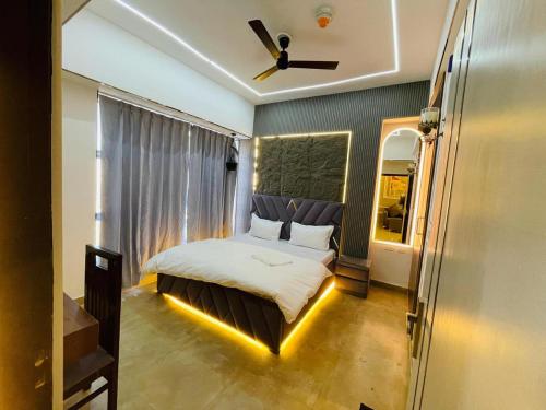 a bedroom with a bed with a ceiling fan at Cozy Noida studio,Super comfy! in Noida