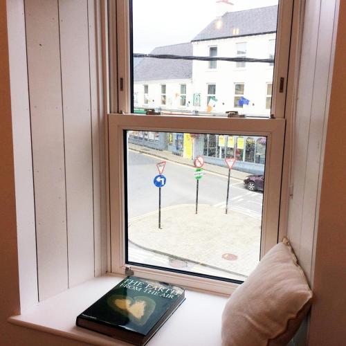 a book sitting on a window sill with a view of a street at Luxury Loft Apartment with Stunning Roof Garden in Killorglin