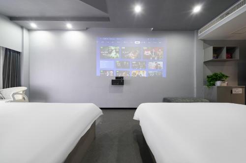 a room with two beds and a white wall at Qijianyunshe in Hanqiyu