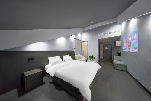a bedroom with a large white bed and a tv at Qijianyunshe in Hanqiyu