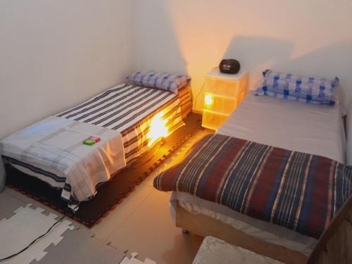 1 dormitorio con 2 camas en una habitación con suelo en hspedagemfuncional, en Porto Alegre