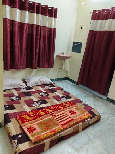 a bedroom with a bed with a quilt on it at AMC Homestay in Tiruvannāmalai