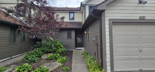 a garage next to a house with a driveway at Cozy Condo- 3 bedroom lakefront condo with fireplace in McHenry