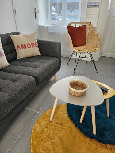 a living room with a couch and a table at Le Story Home in Fougères