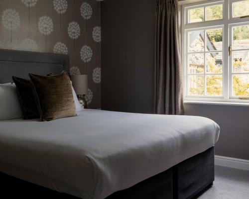 a bedroom with a large bed with a window at Lyzzick Hall Hotel in Keswick