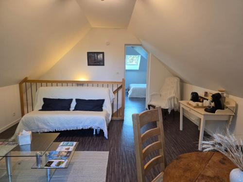 una camera mansardata con letto e tavolo di Logement sur la Loire à vélo a Montlouis-sur-Loire