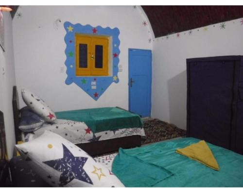 a room with two beds and a mirror on the wall at Shekos guset house in Jazīrat Suhayl