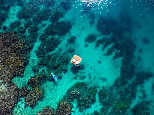 an aerial view of two people in the ocean at The Remote Resort in Nawi