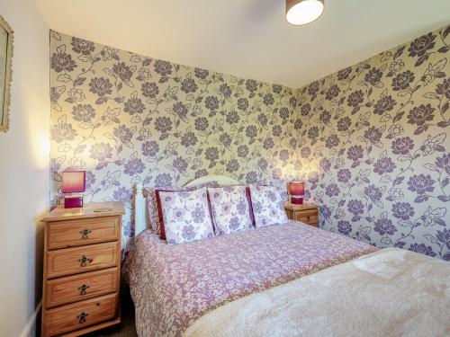 a bedroom with a bed and two night stands with lamps at Brynawel in Bryncroes