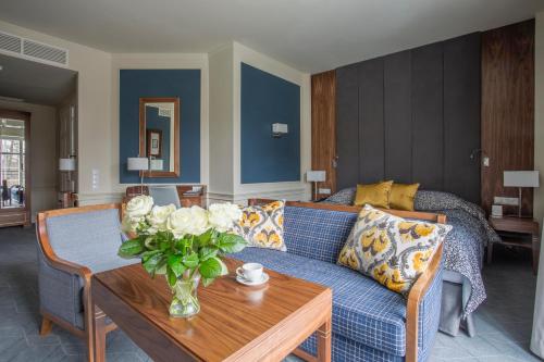 a living room with a blue couch and a table at Hotel SPA Dr Irena Eris Polanica Zdrój in Polanica-Zdrój