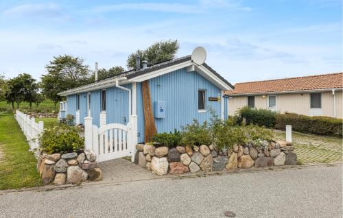 a blue house with a white fence in front of it at Friedrichskoog-Deichblick 4 in Friedrichskoog