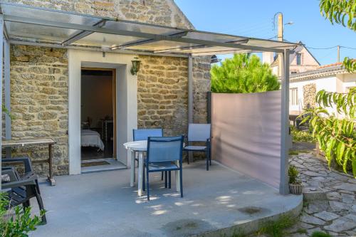 a patio with a table and chairs under a pergola at L'Eclose in Le Guilvinec