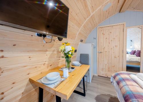 a wooden room with a table and a tv at Hill Farm Retreat in Wangford