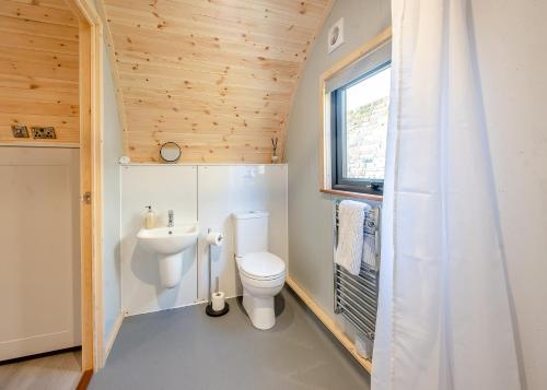 a small bathroom with a toilet and a sink at Hill Farm Retreat in Wangford