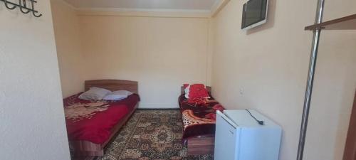 a small bedroom with a bed and a suitcase at Гостевой дом in Cholpon-Ata