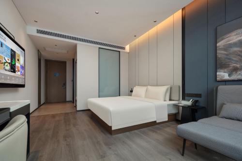 a bedroom with a white bed and a couch at Atour Hotel Foshan Chancheng Zhangcha in Foshan