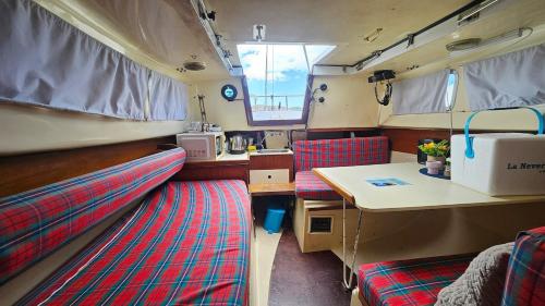 a room with two beds and a table in a bus at Lisbon Classic Boat 25 Belém in Lisbon