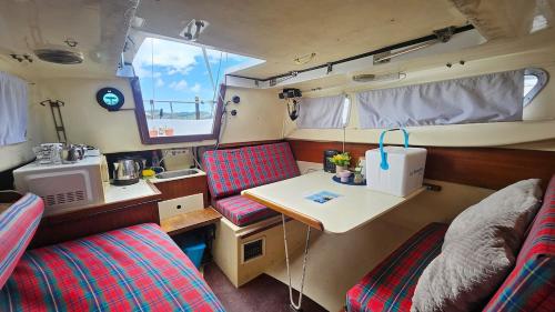 a small room with a table and chairs in a rv at Lisbon Classic Boat 25 Belém in Lisbon