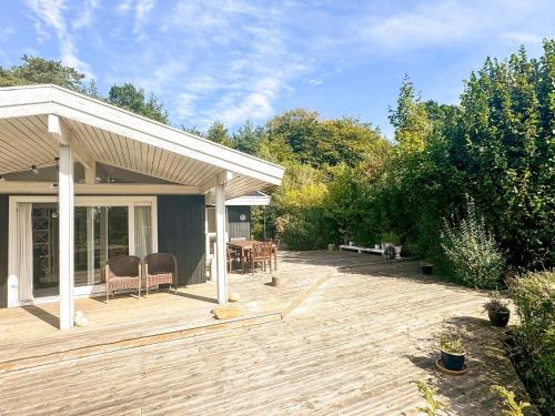 a wooden deck with a table and chairs on it at 6 person holiday home in Dronningmølle-By Traum in Hornbæk