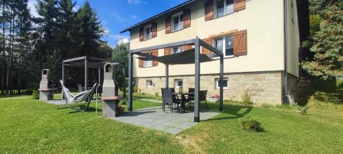 une maison avec un panier de basket et une table dans la cour dans l'établissement 2chałupy - apartamenty w Soli, à Sól