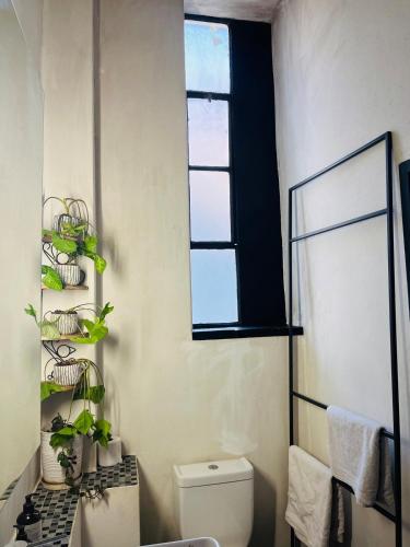 a bathroom with a toilet and a window at Lofty Hipster in Johannesburg