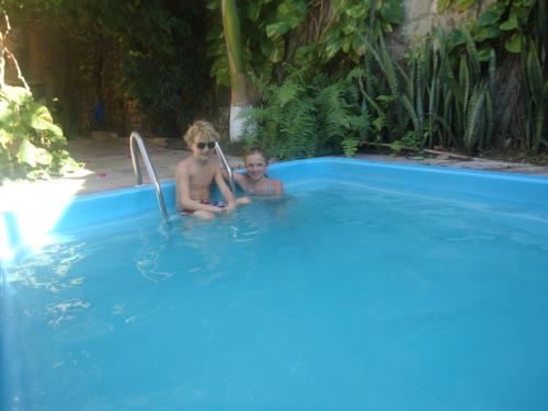 um homem e uma criança sentados numa piscina em Hotel Morro do Careca em Natal