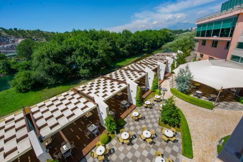 una vista aérea de un edificio con mesas y sombrillas en Luani A Hotel en Shkodër