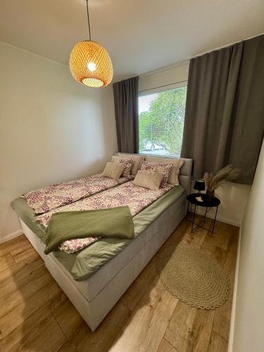 a bedroom with a large bed with a window at Tullikatu Two-Bedroom Apartment in Kristinestad