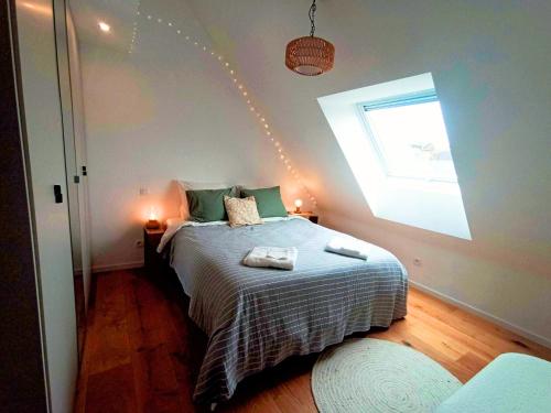 a bedroom with a large bed with a window at Sous les Étoiles de Gaume in Virton