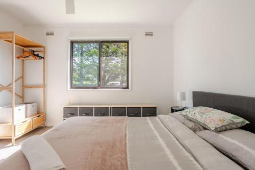 a bedroom with a large bed and a window at All in One Home Work, Relax & Weekend Escape in Bomaderry