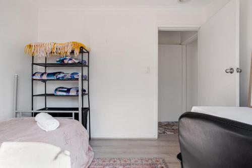 a bedroom with a bed and a rack of clothes at All in One Home Work, Relax & Weekend Escape in Bomaderry