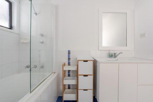 a white bathroom with a sink and a shower at All in One Home Work, Relax & Weekend Escape in Bomaderry
