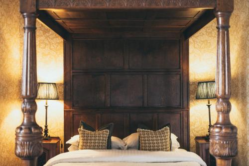 a bedroom with a large wooden bed with pillows at Rowton Castle in Shrewsbury