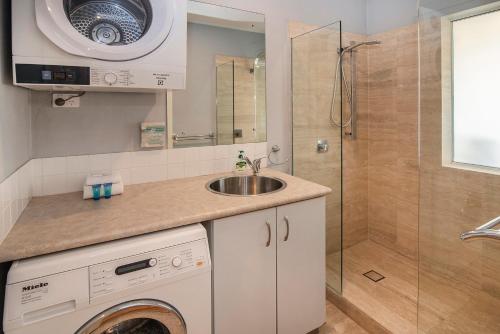 a bathroom with a sink and a washing machine at Beachside Retreat, WIFI, Kayaks, AC to all rooms in Dunsborough