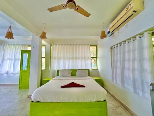 a bedroom with a large white bed with a green platform at Dreamy vibe Stays in Morjim