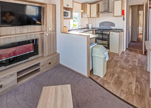 a kitchen with a tv and a counter with a sink at Stanwix Park in Silloth