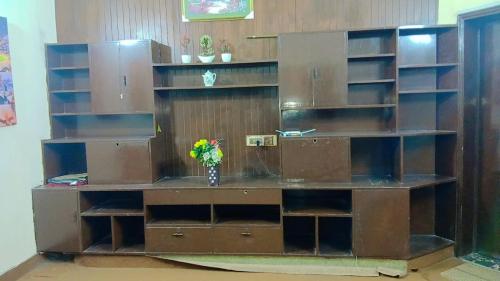 a large book shelf with a vase of flowers in it at Hotel Royal Fort in Lahore