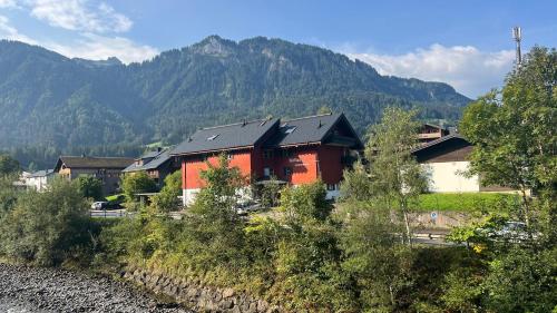a red building with a mountain in the background at Mellau Appartments Top 221 in Mellau